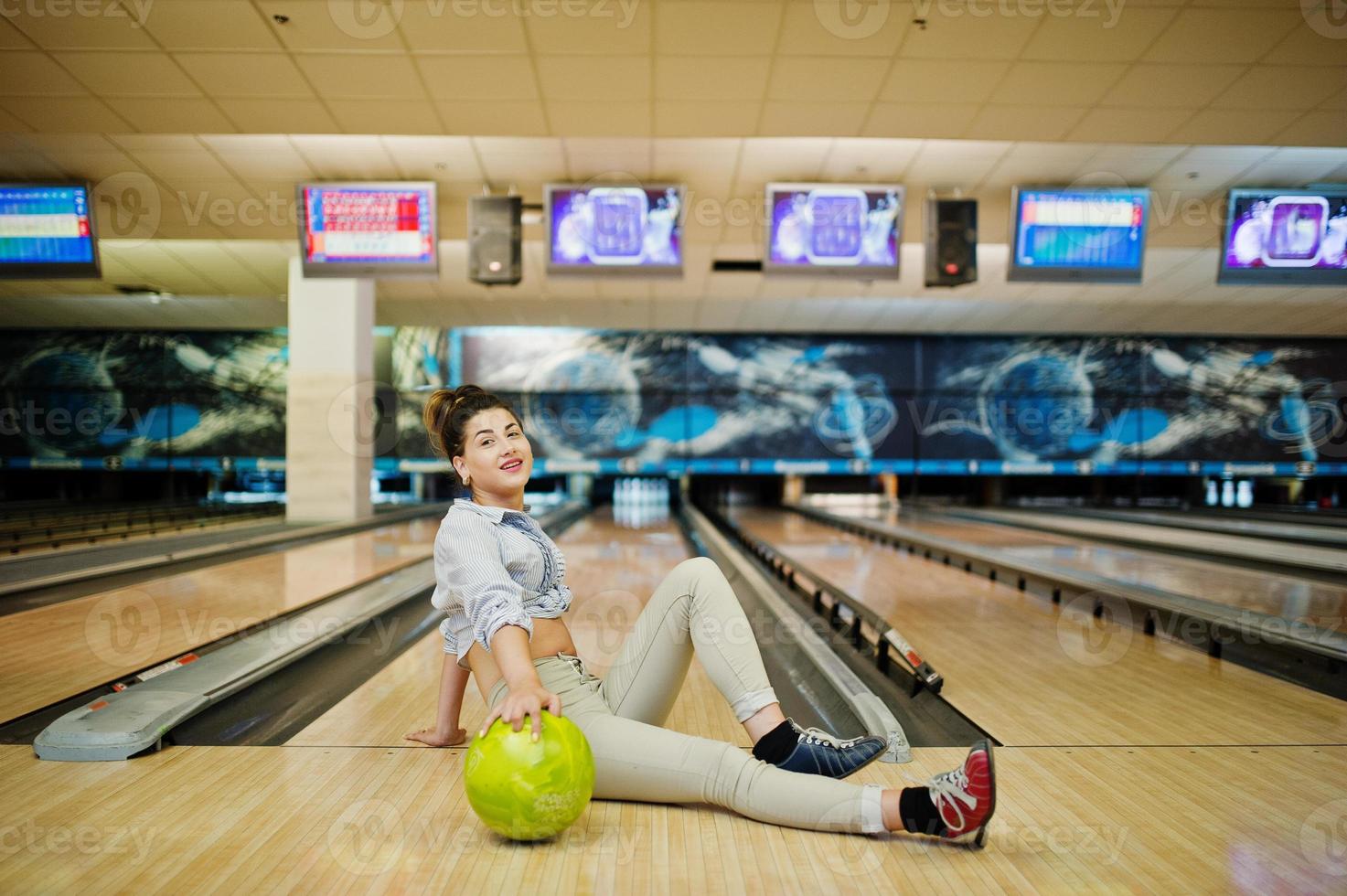 fille avec boule de bowling sur l'allée a joué au club de bowling. photo