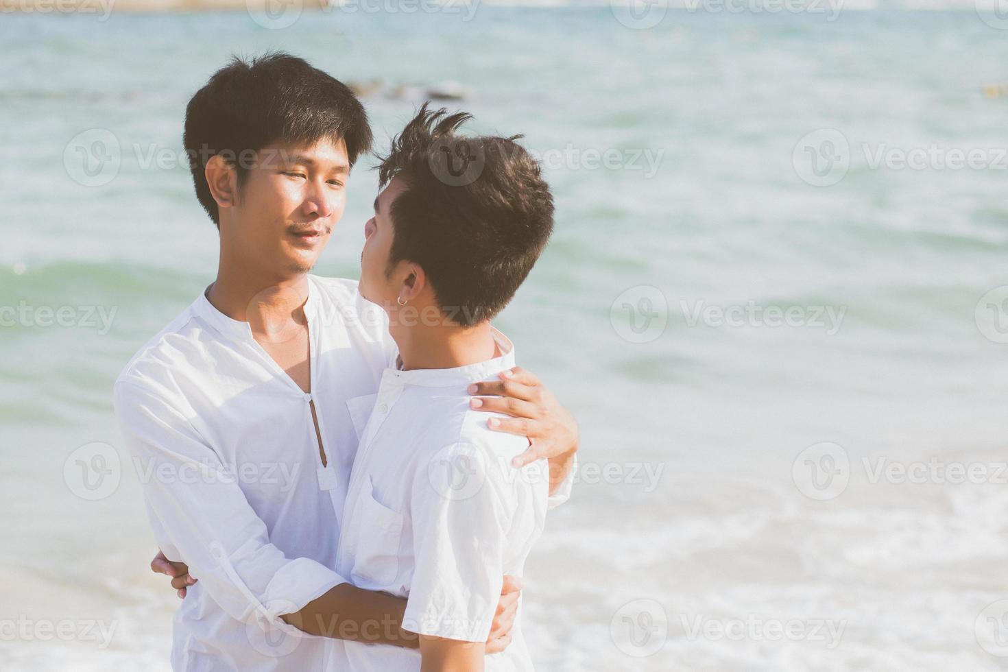 portrait homosexuel jeune couple asiatique debout câlin ensemble sur la plage en été, asie gay va tourisme pour les loisirs et se détendre avec romantique et bonheur en vacances en mer, concept lgbt. photo