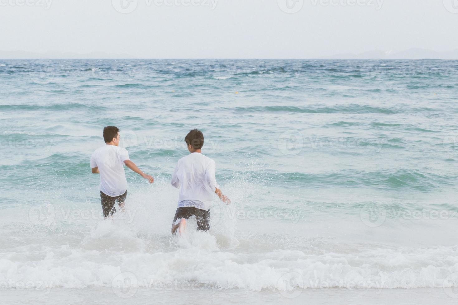 portrait homosexuel jeune couple asiatique courant avec gai ensemble sur la plage en été, asie gay faisant du tourisme pour les loisirs et se détendre avec bonheur en vacances en mer, concept juridique lgbt. photo