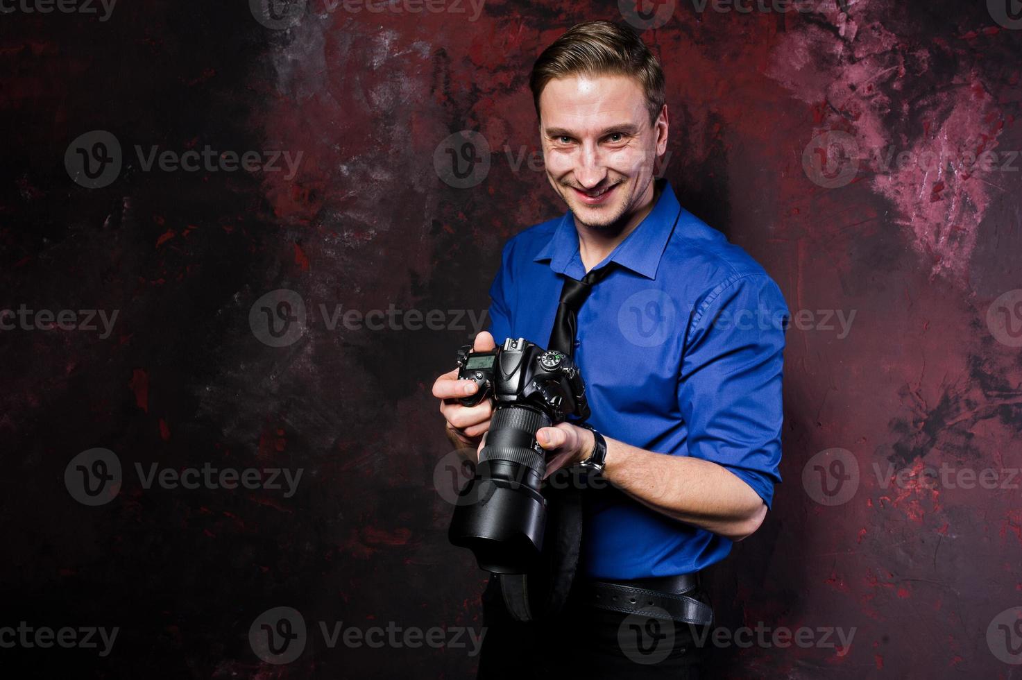 portrait en studio d'un photographe professionnel élégant avec appareil photo, porter une chemise bleue et une cravate. photo