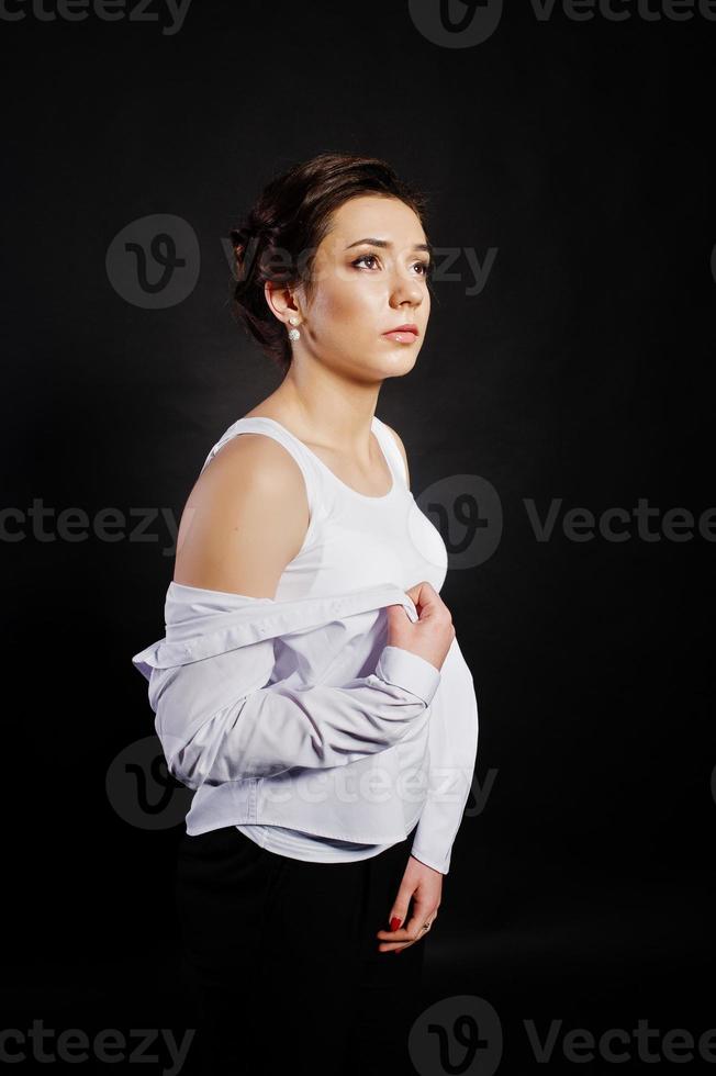 portrait en studio de jeune fille brune avec maquillage sur fond noir. photo