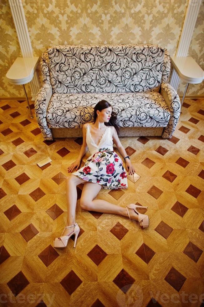 portrait d'une femme étonnante en belle robe allongée sur le parquet. photo