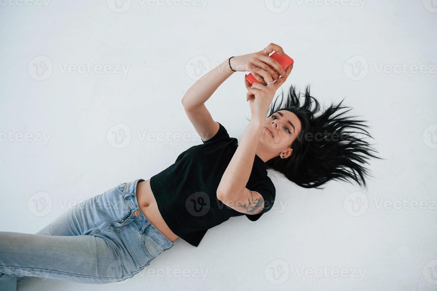 prendre un selfie. jeune femme brune adolescente a une séance photo en studio pendant la journée