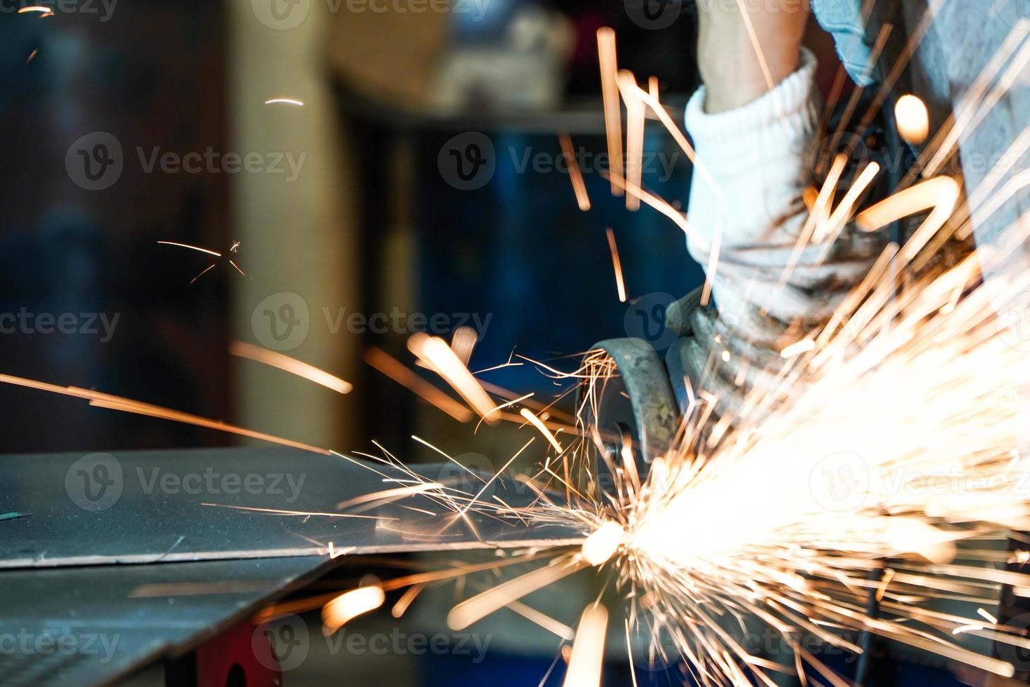 rectifieuse de fer électrique dans les étincelles d'usine des meules photo