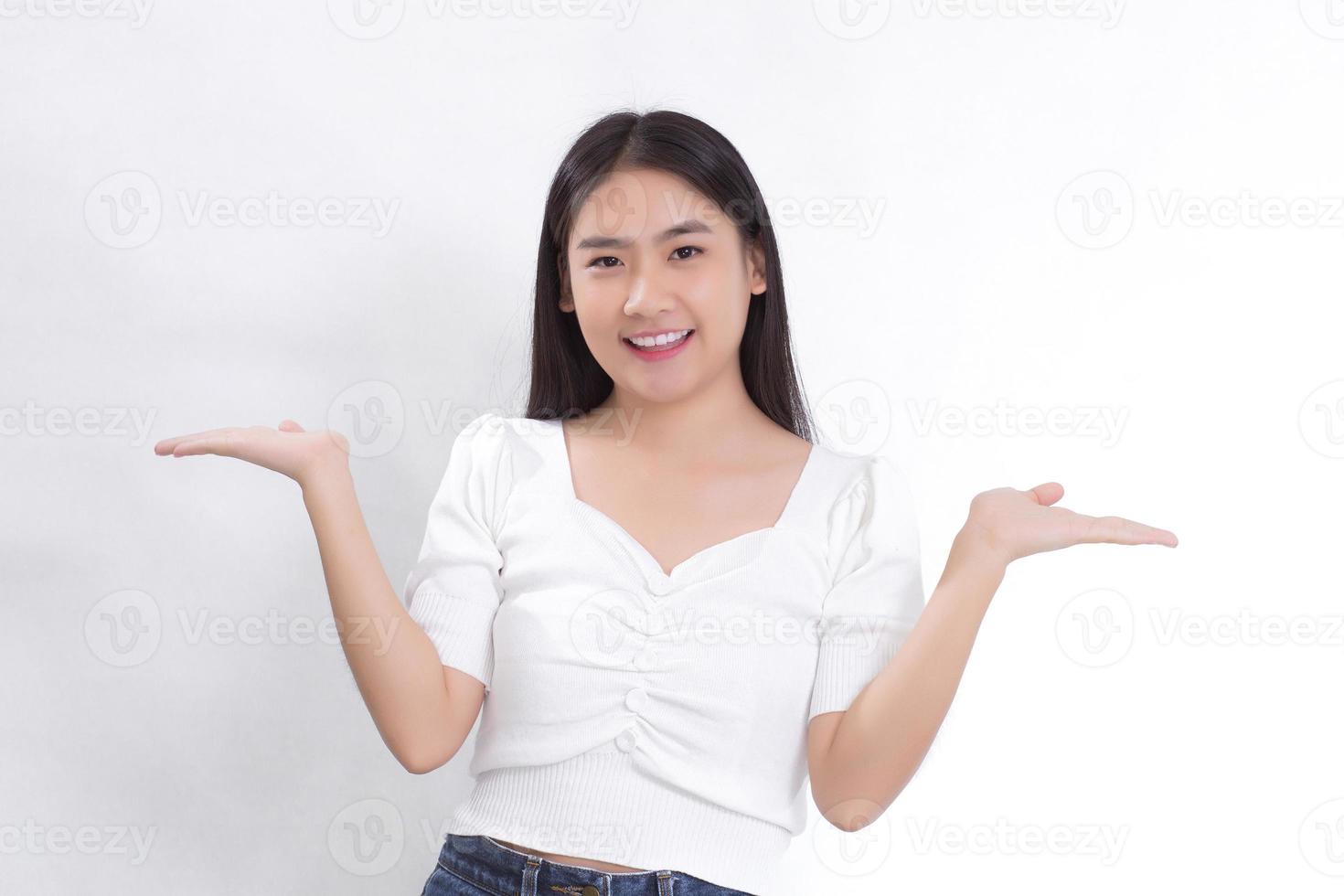 portrait femme asiatique sourit et montre ses mains pour présenter quelque chose sur le fond blanc. photo