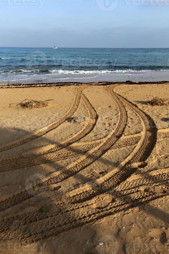 empreintes de pas dans le sable sur les rives de la mer méditerranée dans le nord d'israël photo