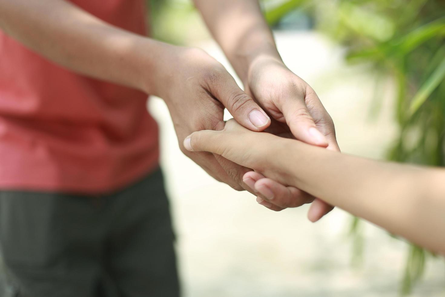 père tenir la main de l'enfant avec amour photo