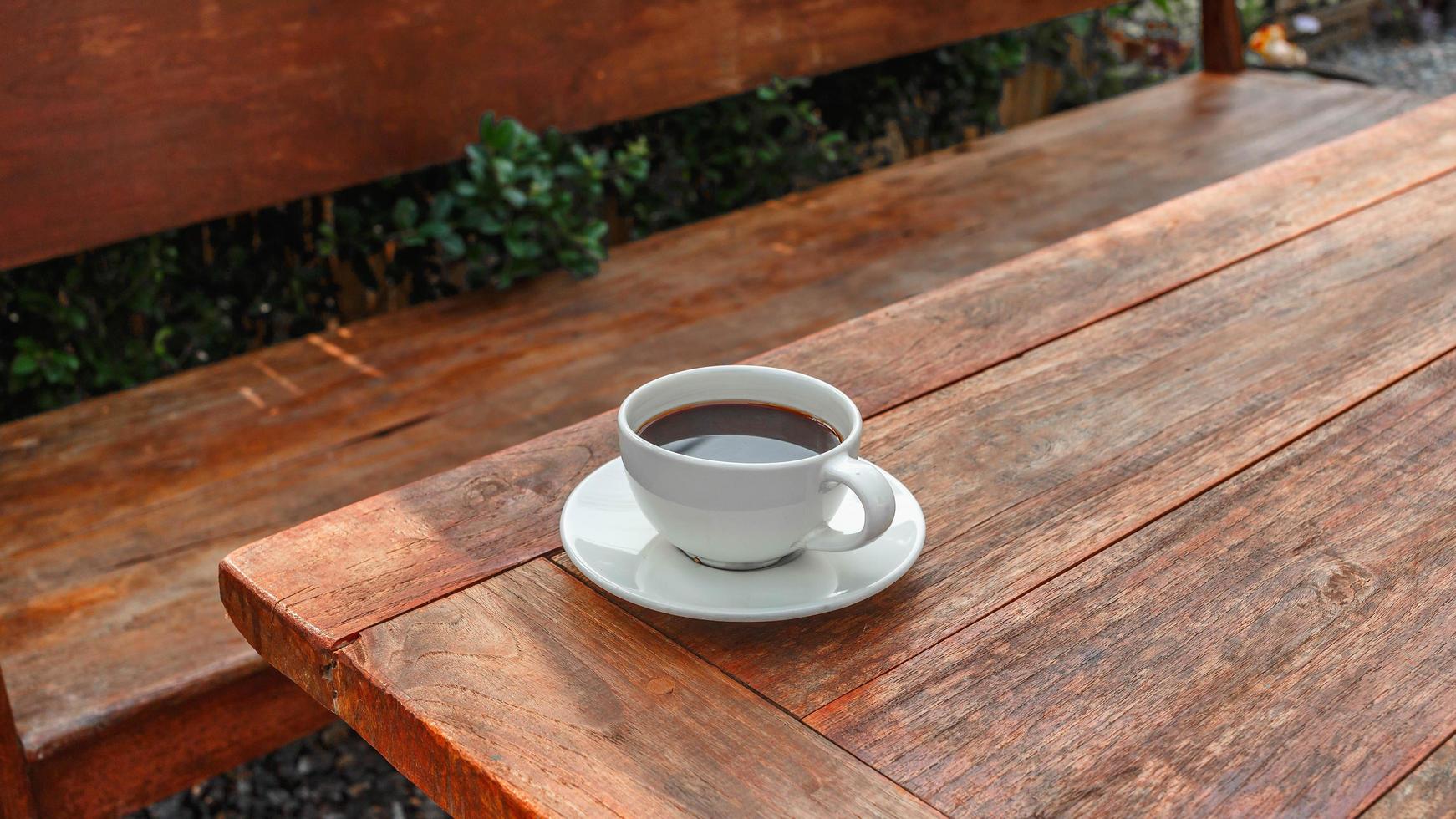 tasse de café sur une table en bois au soleil du matin photo