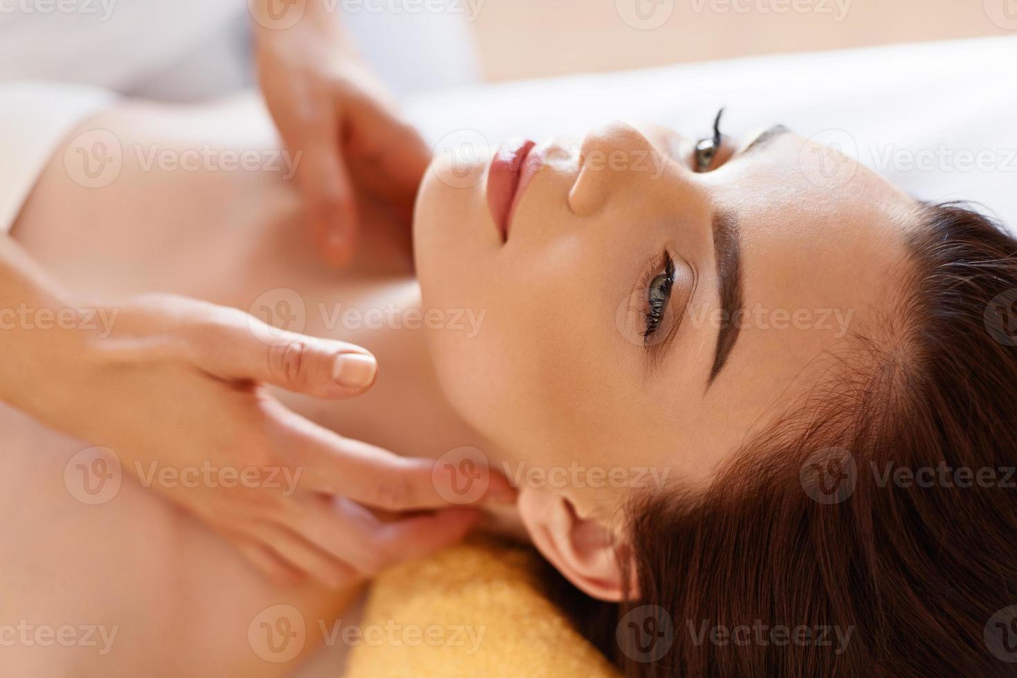 massage spa. belle femme reçoit un traitement de spa au salon. photo