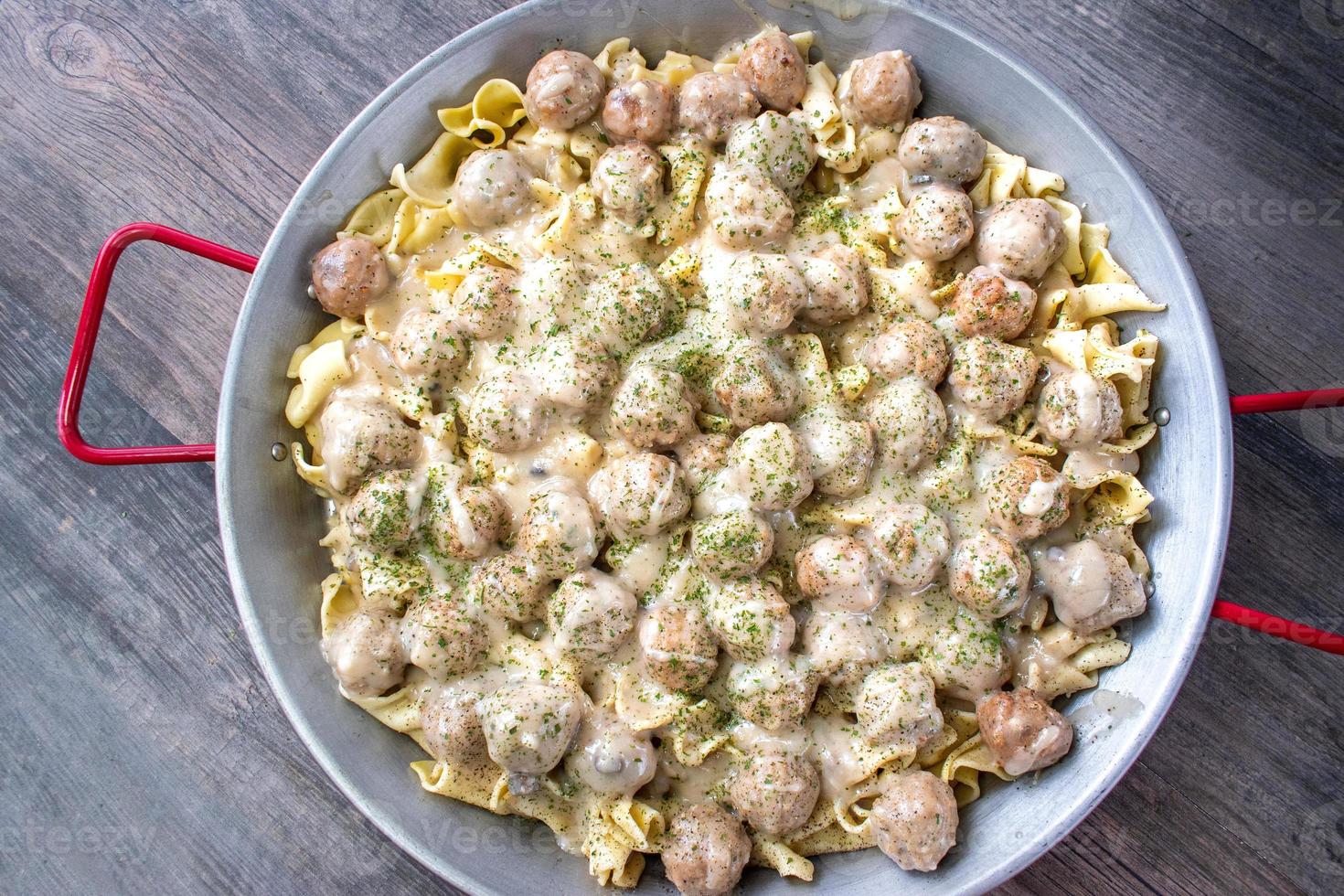 grande casserole de boulettes de viande suédoises sur des nouilles avec sauce à la crème et vue de dessus de persil photo