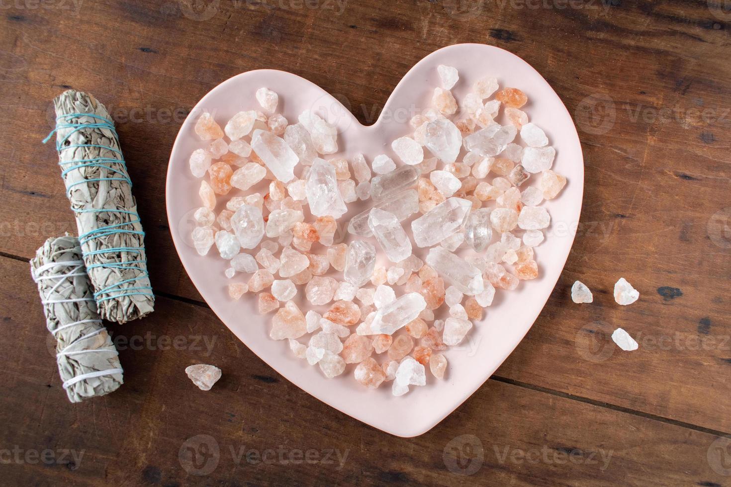 plaque en forme de coeur de guérison remplie de cristaux avec deux bâtons de sauge photo