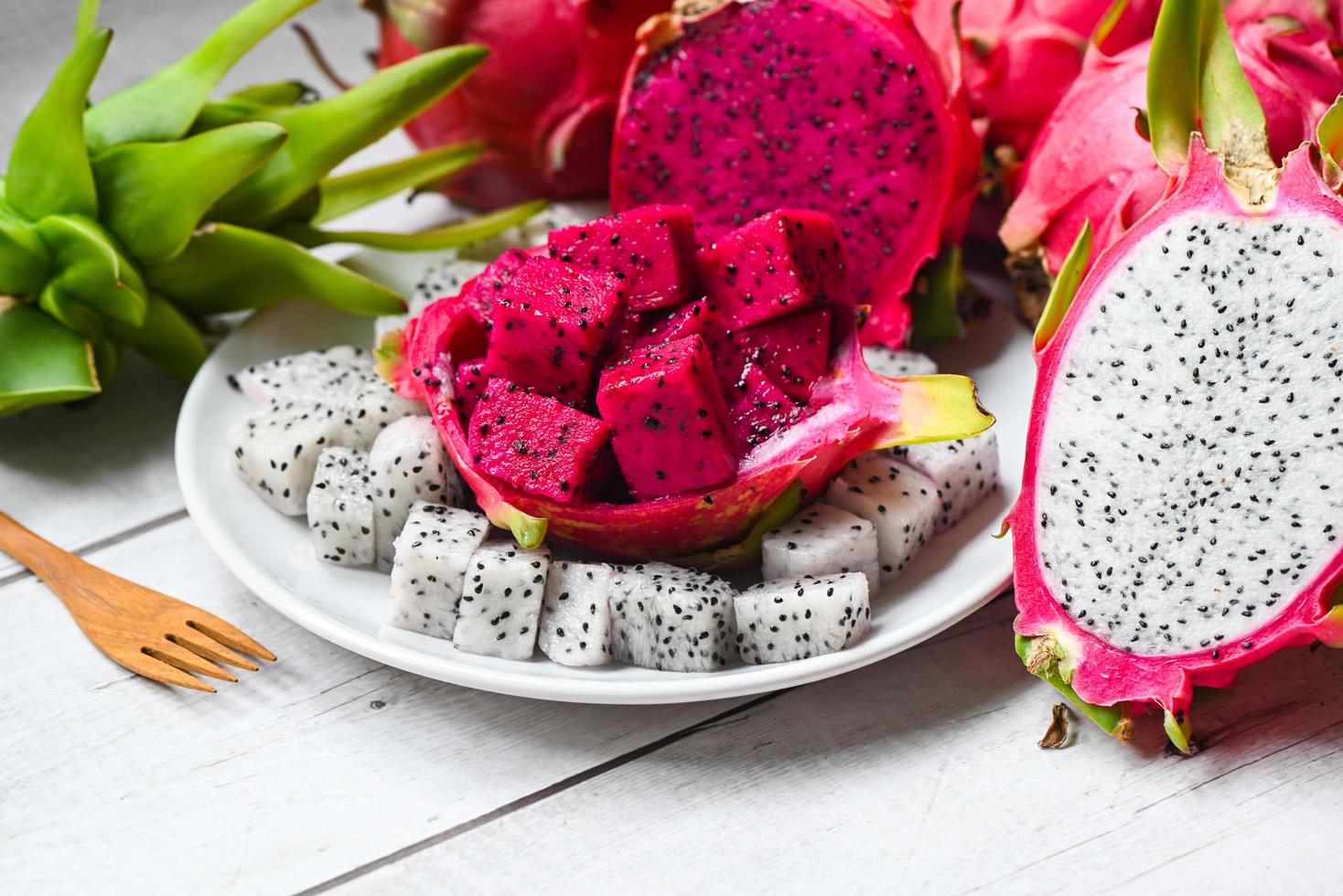 tranche de fruit du dragon et coupez la moitié sur une plaque blanche avec fond pitahaya, fruit du dragon frais blanc et rouge violet tropical dans le concept de fruits sains de la thaïlande asiatique photo