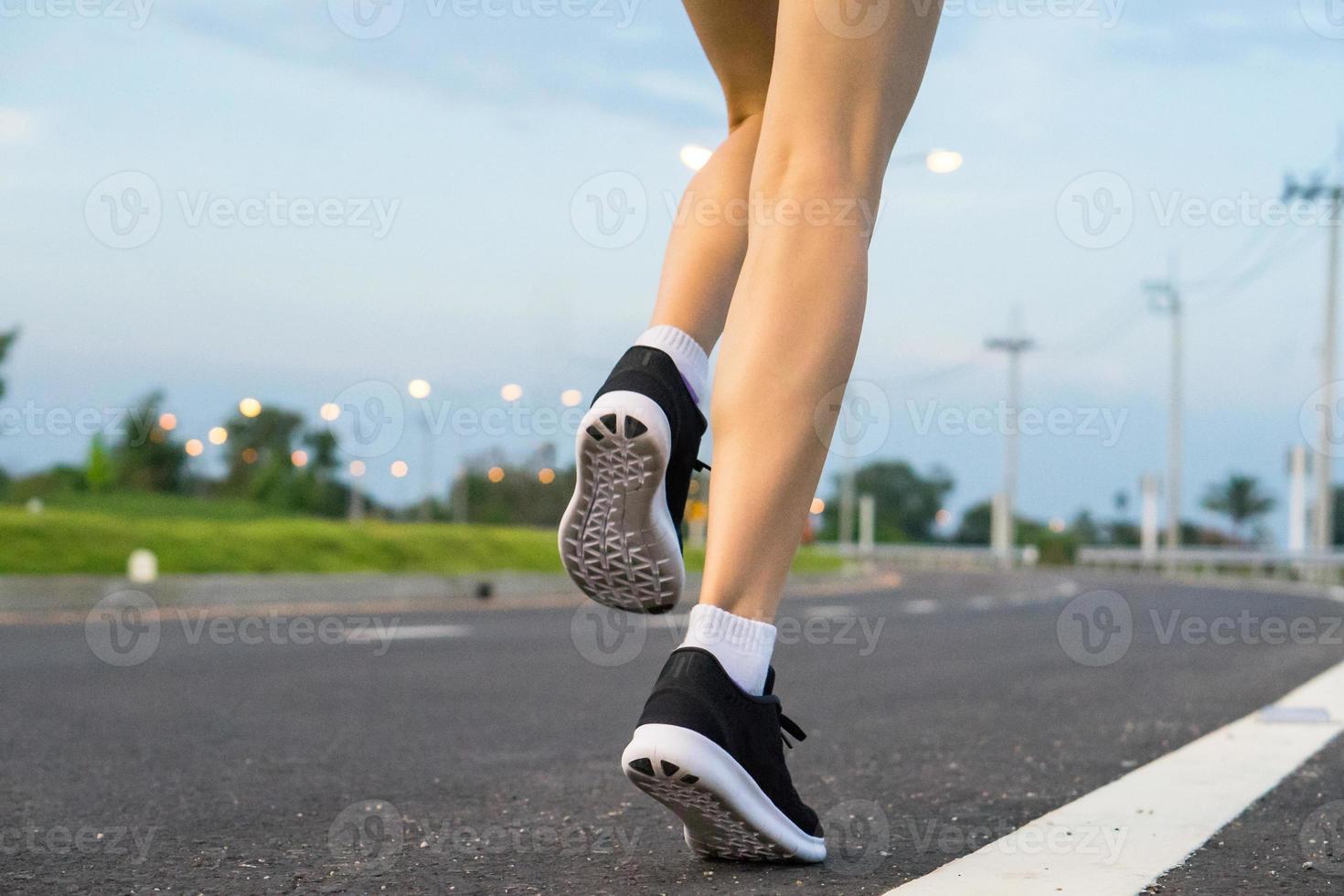 mouvement. jambes de femme en cours d'exécution sur la route goudronnée. photo
