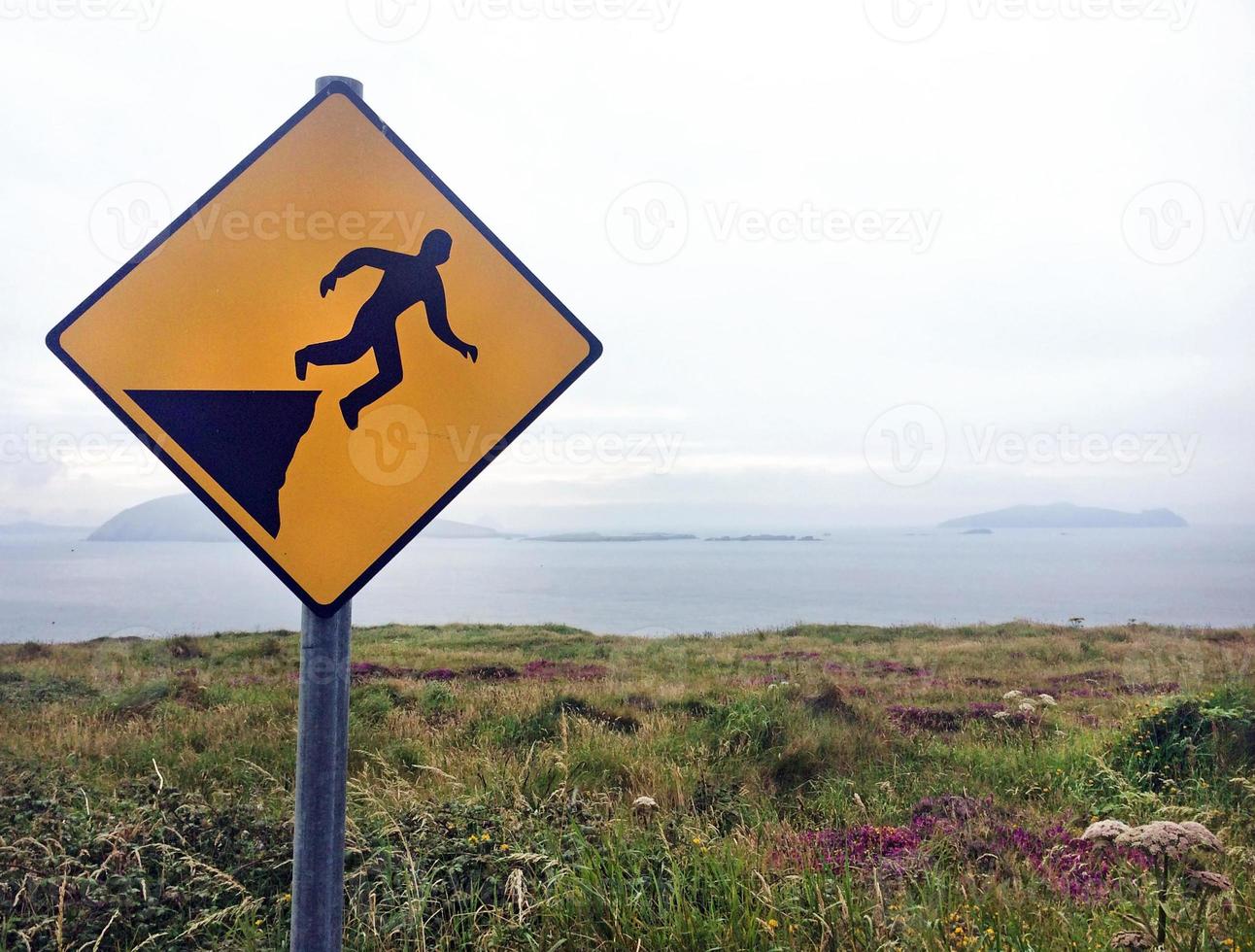 Panneau d'avertissement falaise dangereuse avec l'océan en arrière-plan photo
