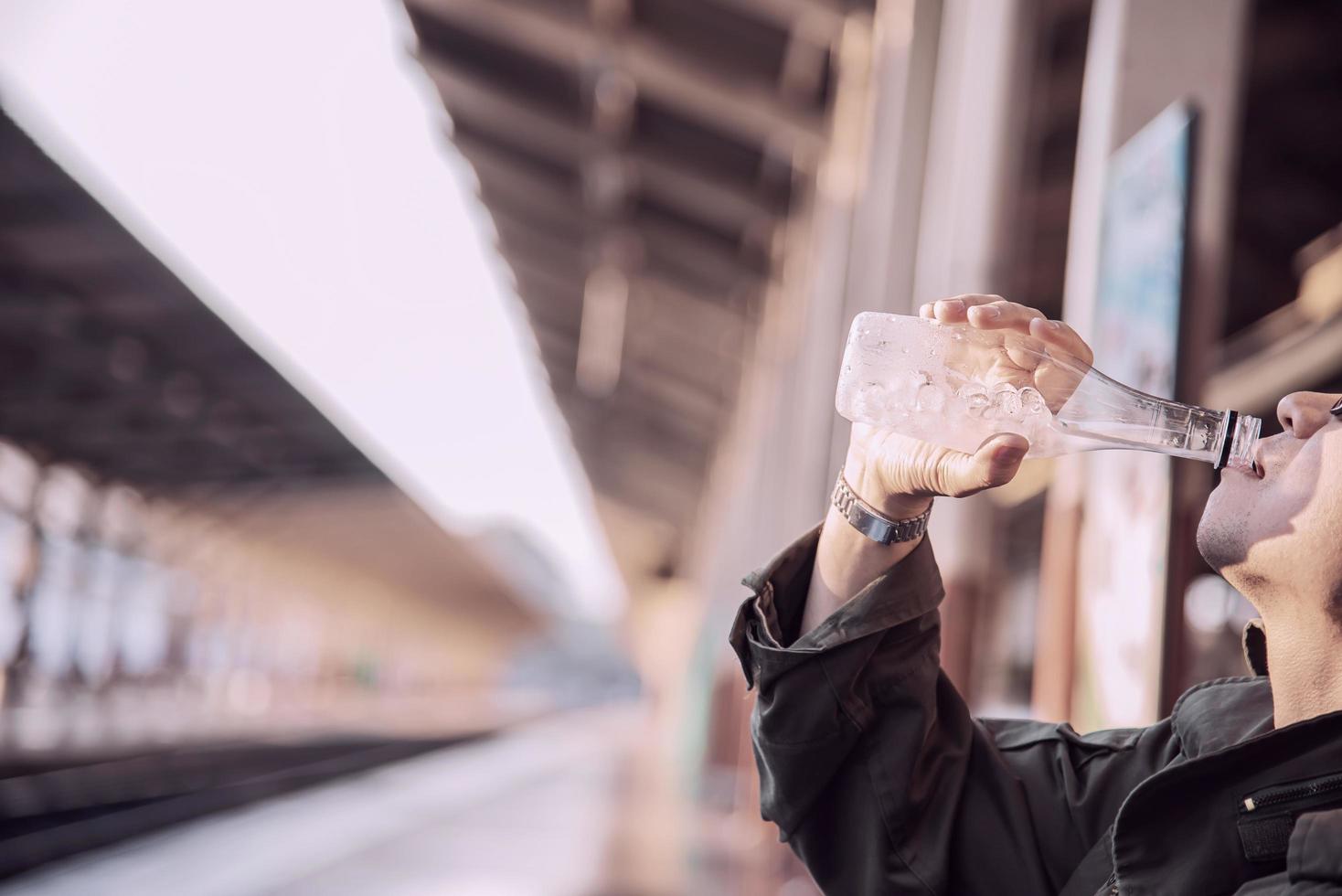 homme de voyage attendre le train à la plate-forme - activités de vie de vacances des gens au concept de transport de la gare photo