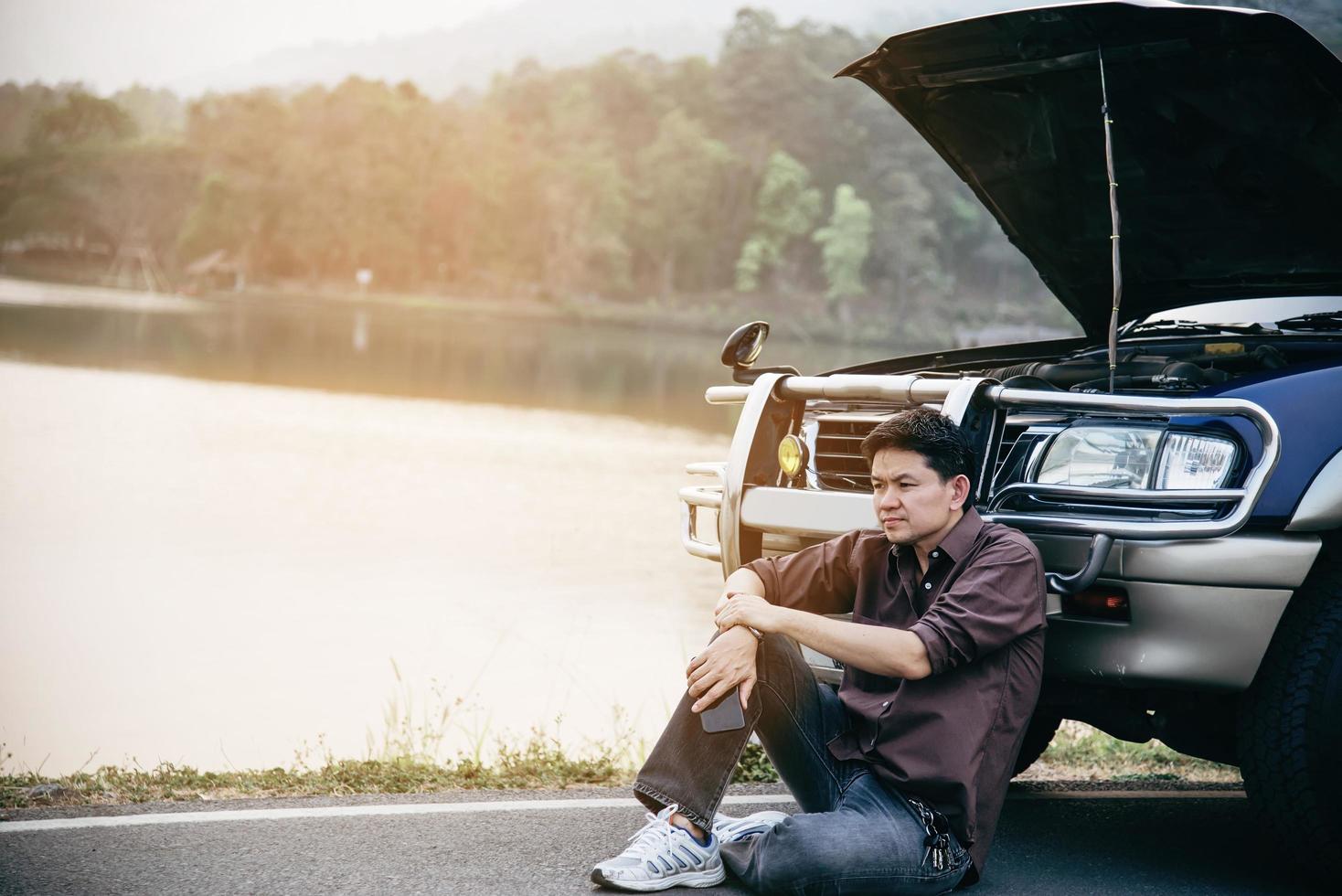 un homme essaie de résoudre un problème de moteur de voiture sur une route locale chiang mai thaïlande - les personnes ayant un problème de voiture concept de transport photo