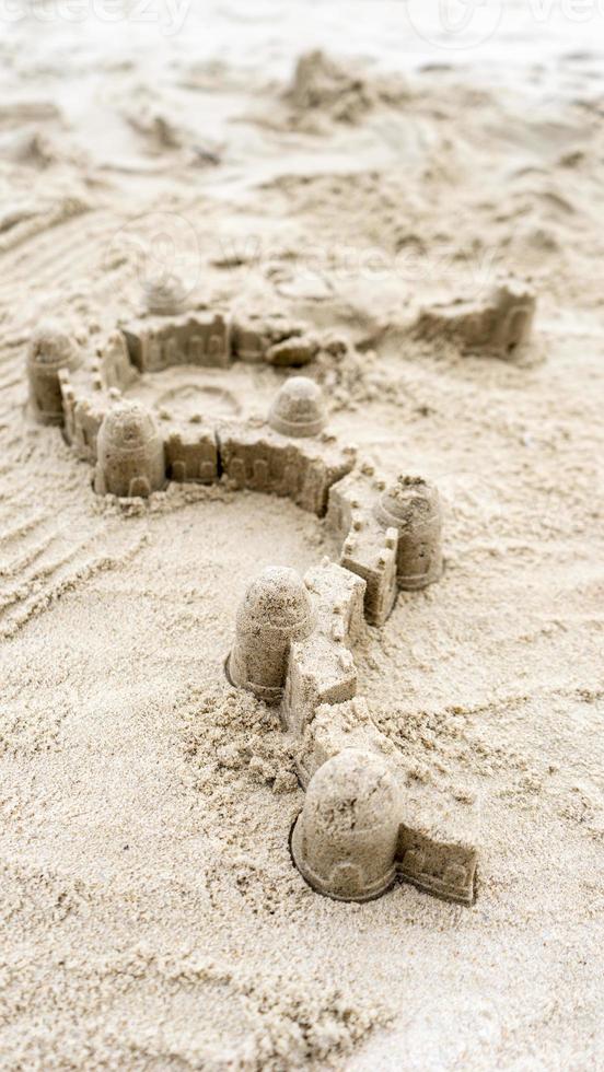 château de sable et barrière murale sur la plage de sable pendant la journée d'été photo