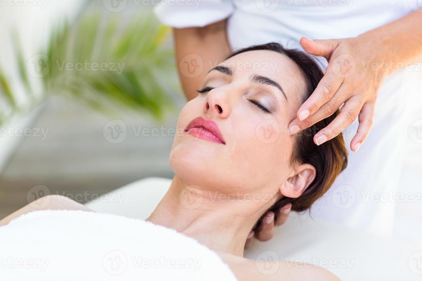 brune recevant un massage de la tête photo