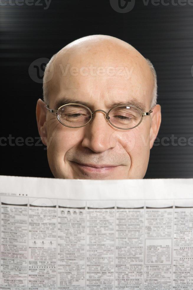 homme caucasien, lisant le journal. photo