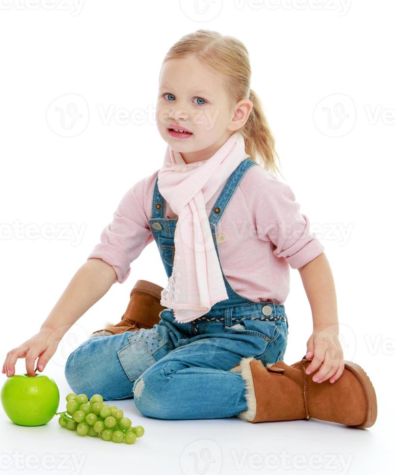 petite fille assise sur le sol et tenant une main photo