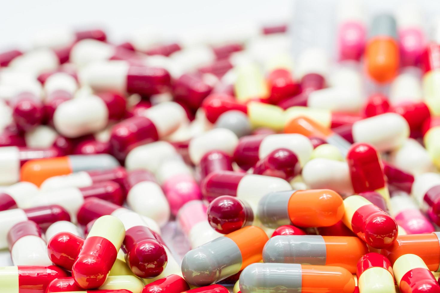 mise au point sélective sur les pilules de capsules antibiotiques sur fond flou de capsules. industrie pharmaceutique. production de drogue. soins de santé mondiaux. interaction médicamenteuse. la résistance aux antibiotiques et la surconsommation. photo