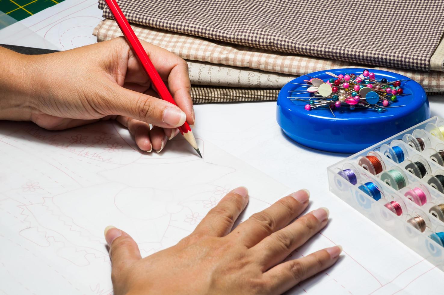 une femme dessine un patron de couture pour son travail de broderie photo