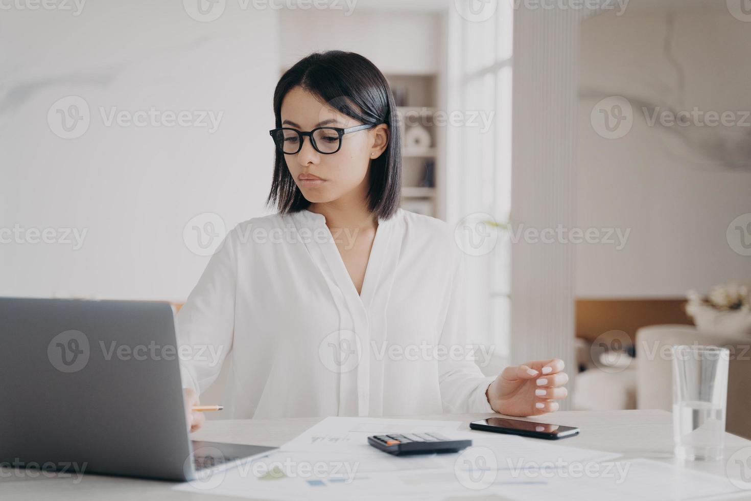 une femme d'affaires européenne concentrée travaille à distance de chez elle. concept de réussite et de carrière. photo