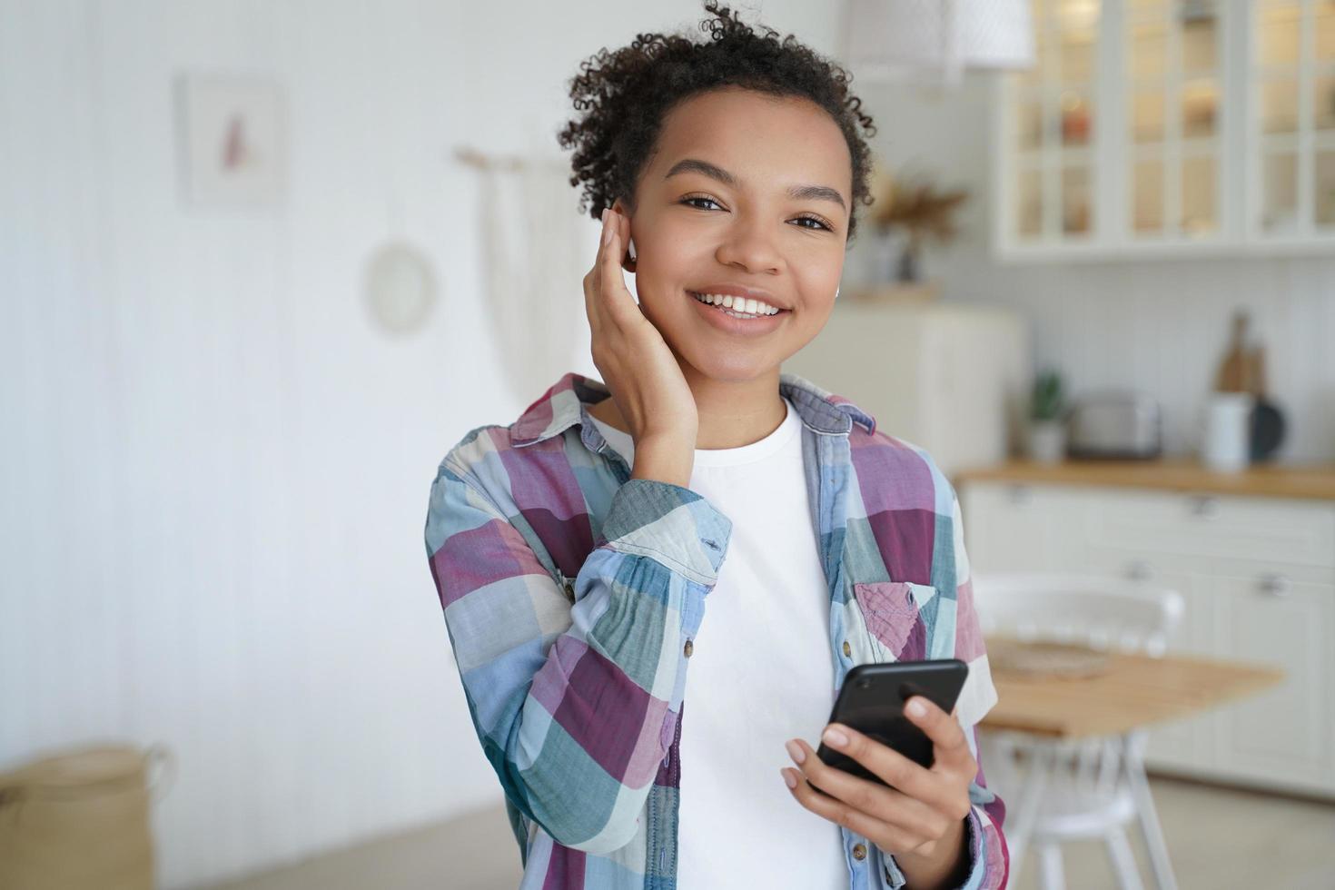 adolescente heureuse appréciant le podcast de musique écoutant dans des écouteurs sans fil. loisirs à la maison. photo