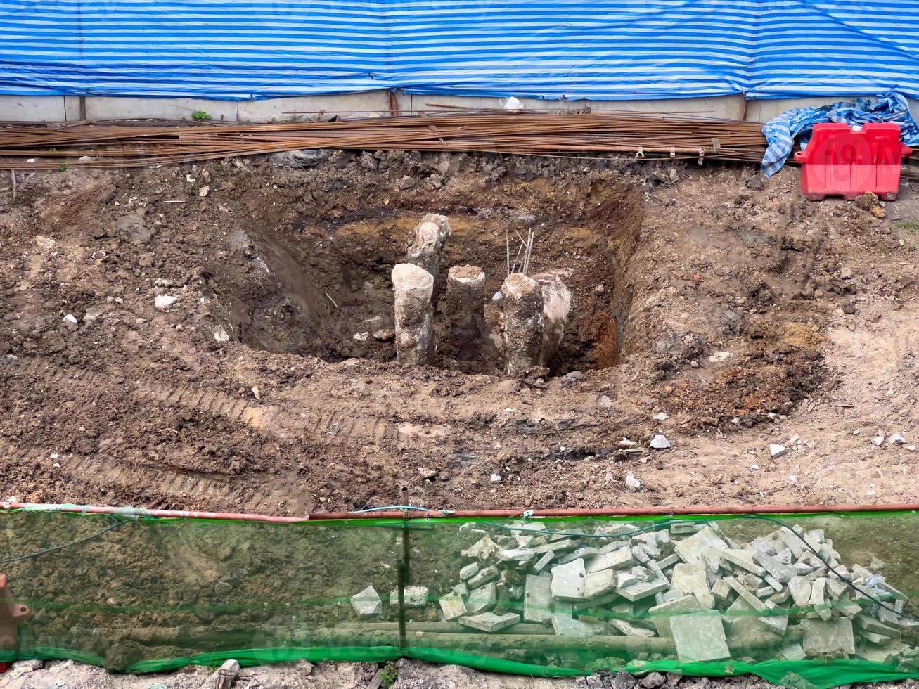 le poteau en béton dans un trou creusé du chantier. photo