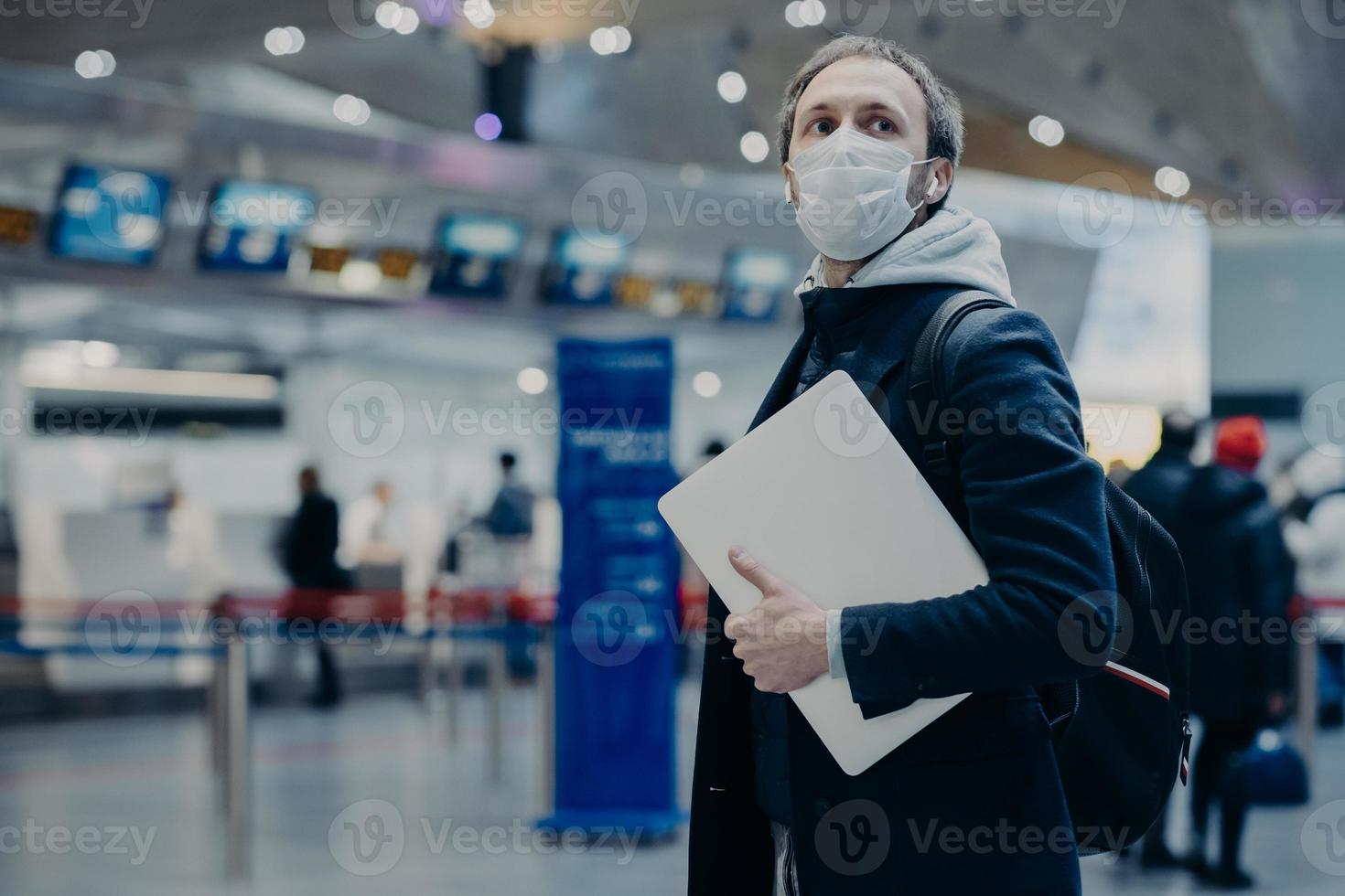 un voyageur porte un masque médical jetable protecteur à l