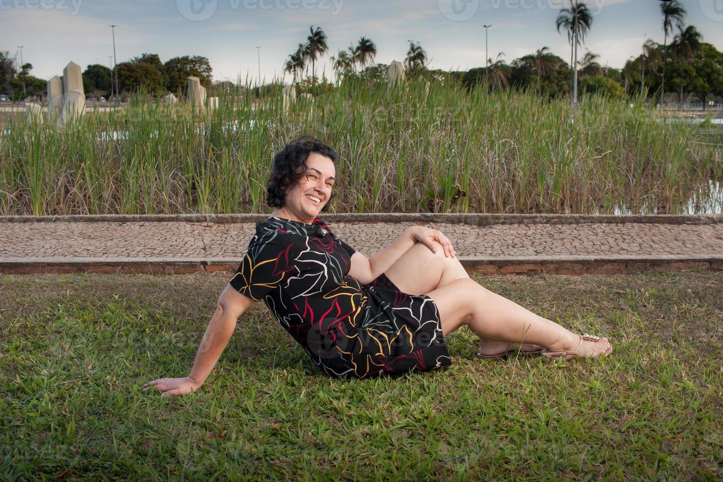 dame au parc allongée sur l'herbe se détendre et profiter de la journée photo