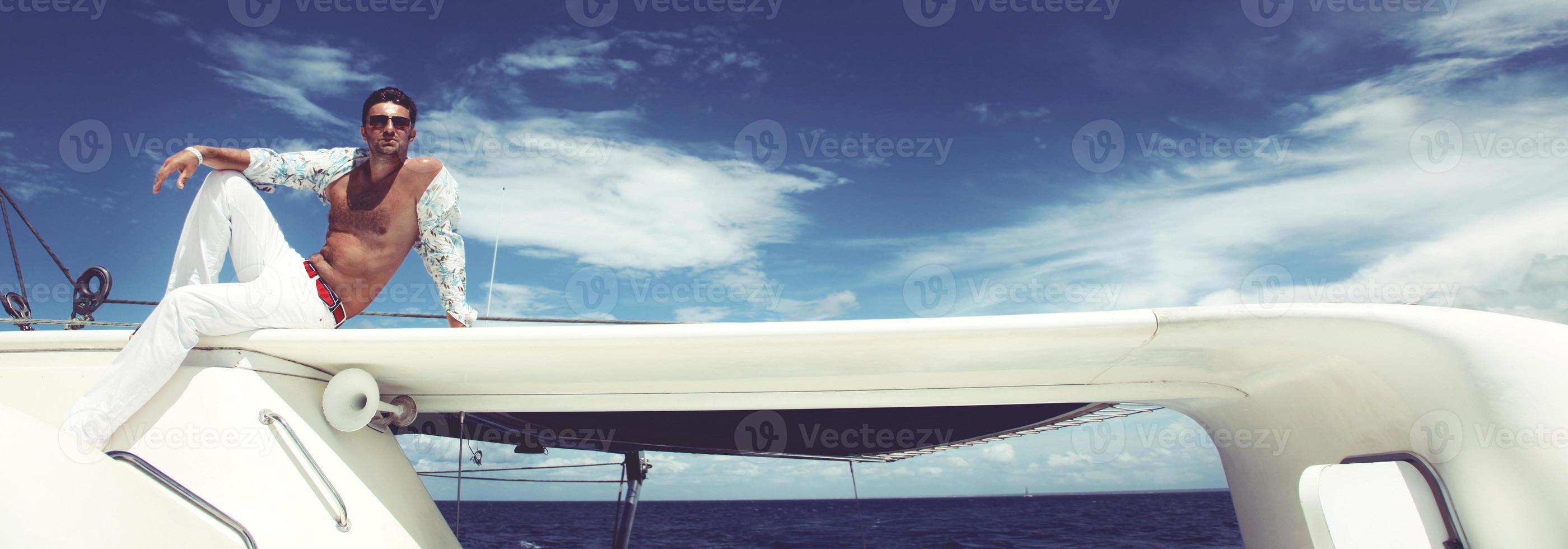 jeune homme naviguant sur son bateau en pleine mer photo