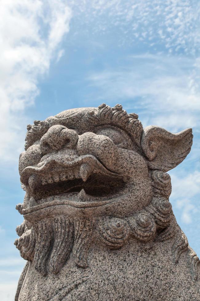 lion de pierre chinois sur fond de ciel bleu photo