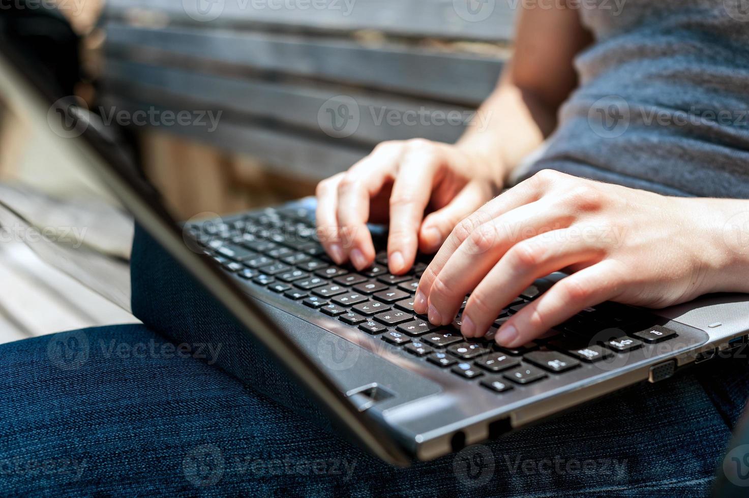 Mains féminines travaillant sur l'ordinateur portable à l'extérieur gros plan photo