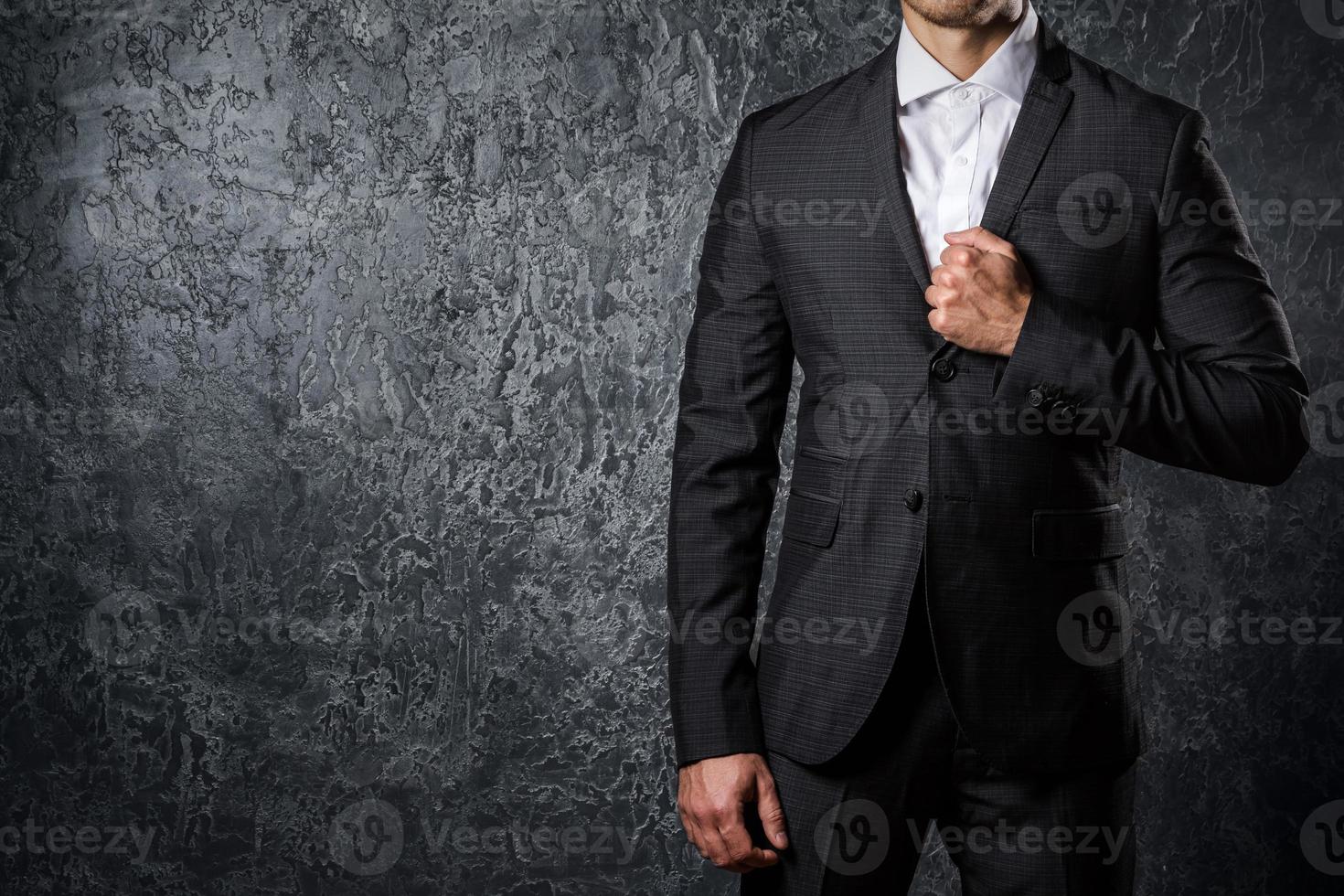 homme en costume contre un mur de béton photo