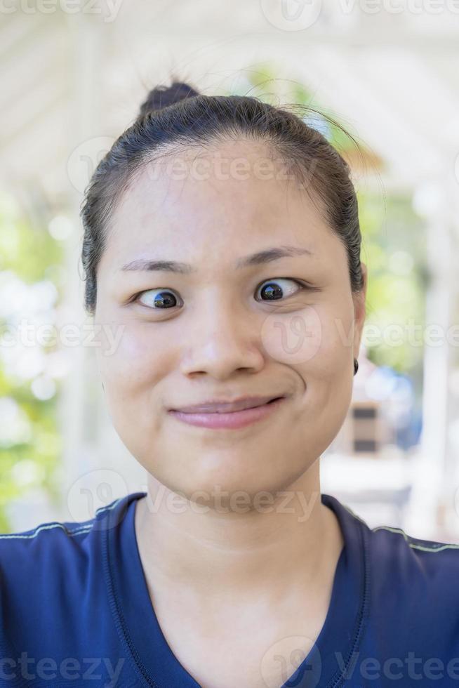 yeux étonnés d'une jeune femme adolescente. une jeune femme asiatique portant des vêtements décontractés fait face au poisson avec des sourires et des gestes fous et comiques. drôle d'expression. photo