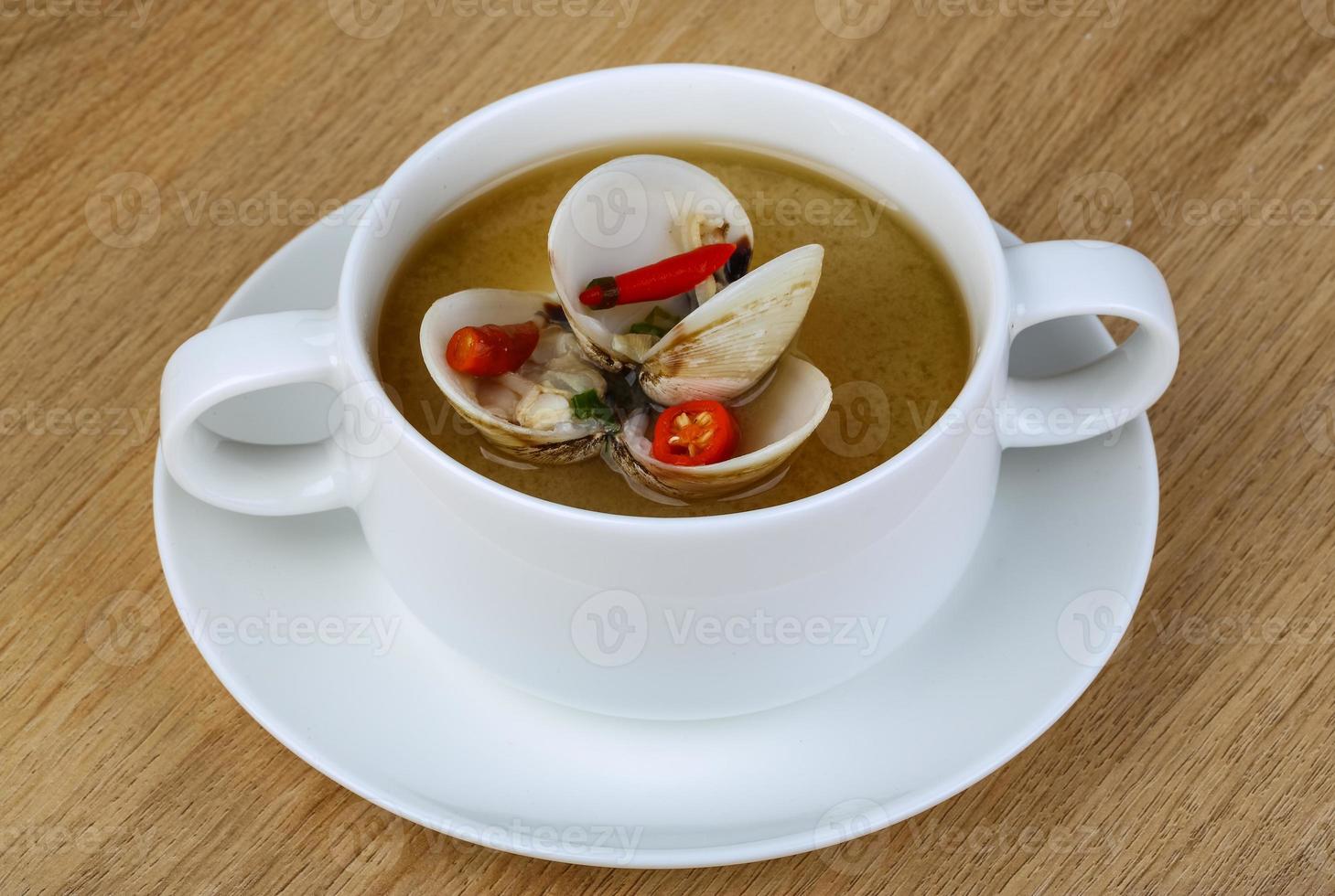 Soupe aux coquillages dans un bol sur fond de bois photo