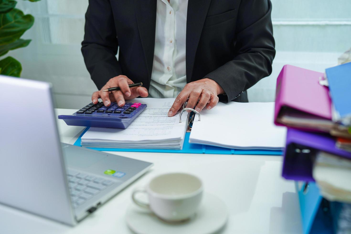 homme d'affaires travaillant et préparant des données de rapport de paperasse pour analyser les informations dans le classeur de fichiers au bureau. photo