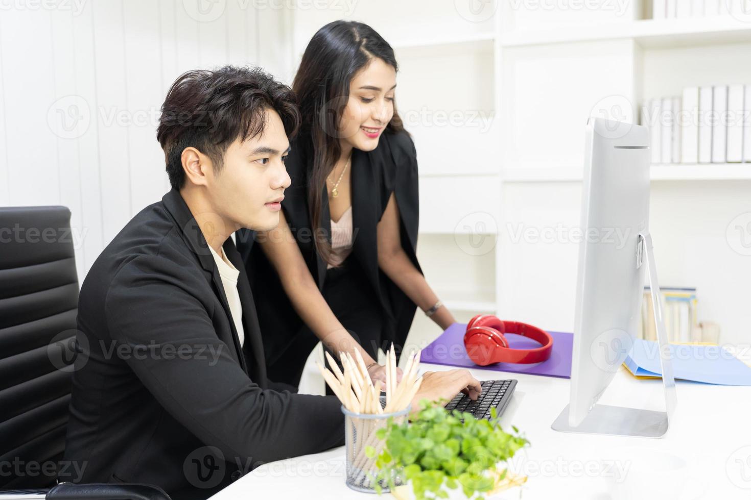 président et secrétaire utilisant un ordinateur pour travailler et discuter ensemble au bureau. homme d'affaires et femme d'affaires parlant et regardant l'ordinateur au bureau. photo