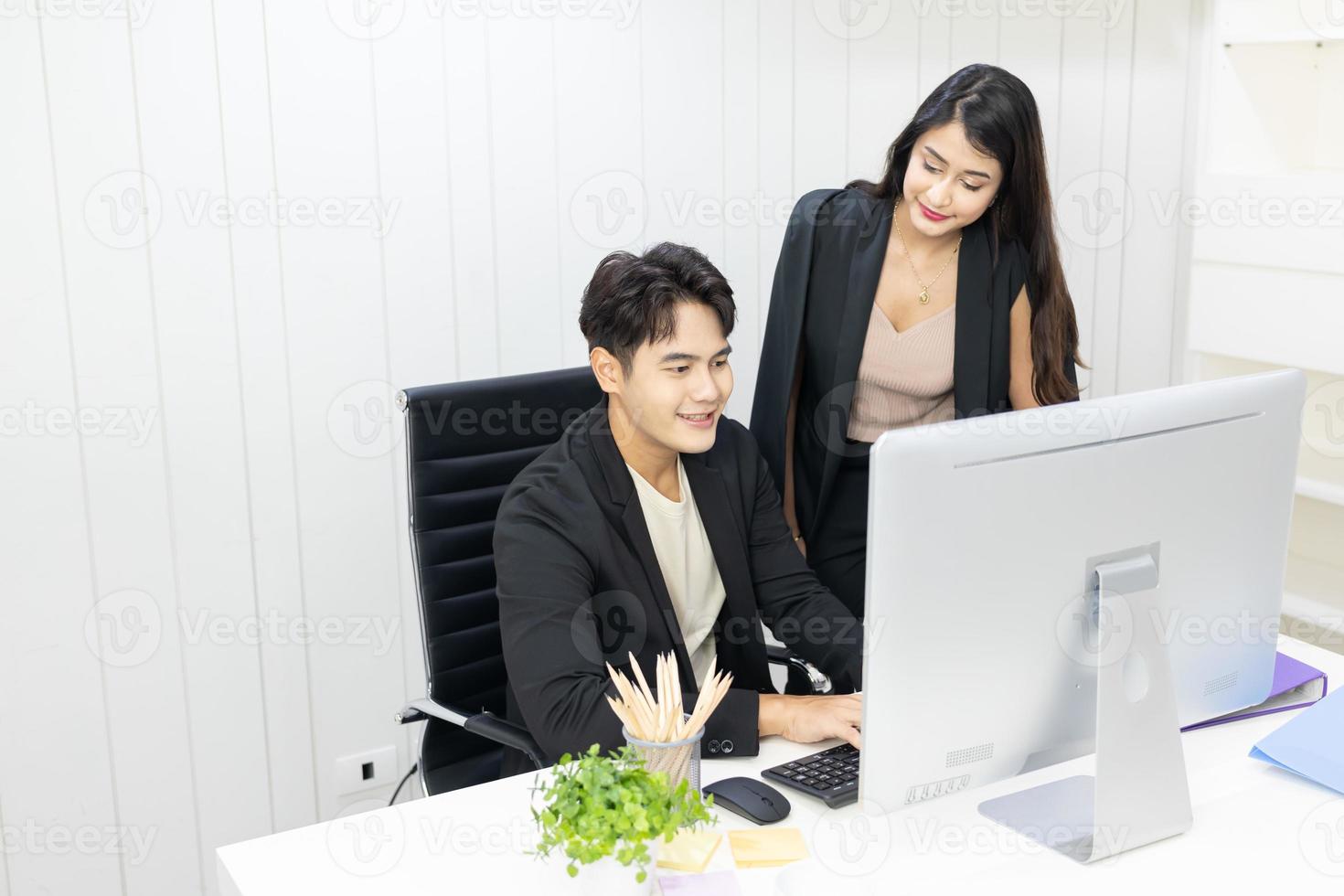 président et secrétaire utilisant un ordinateur pour travailler et discuter ensemble au bureau. homme d'affaires et femme d'affaires parlant et regardant l'ordinateur au bureau. photo