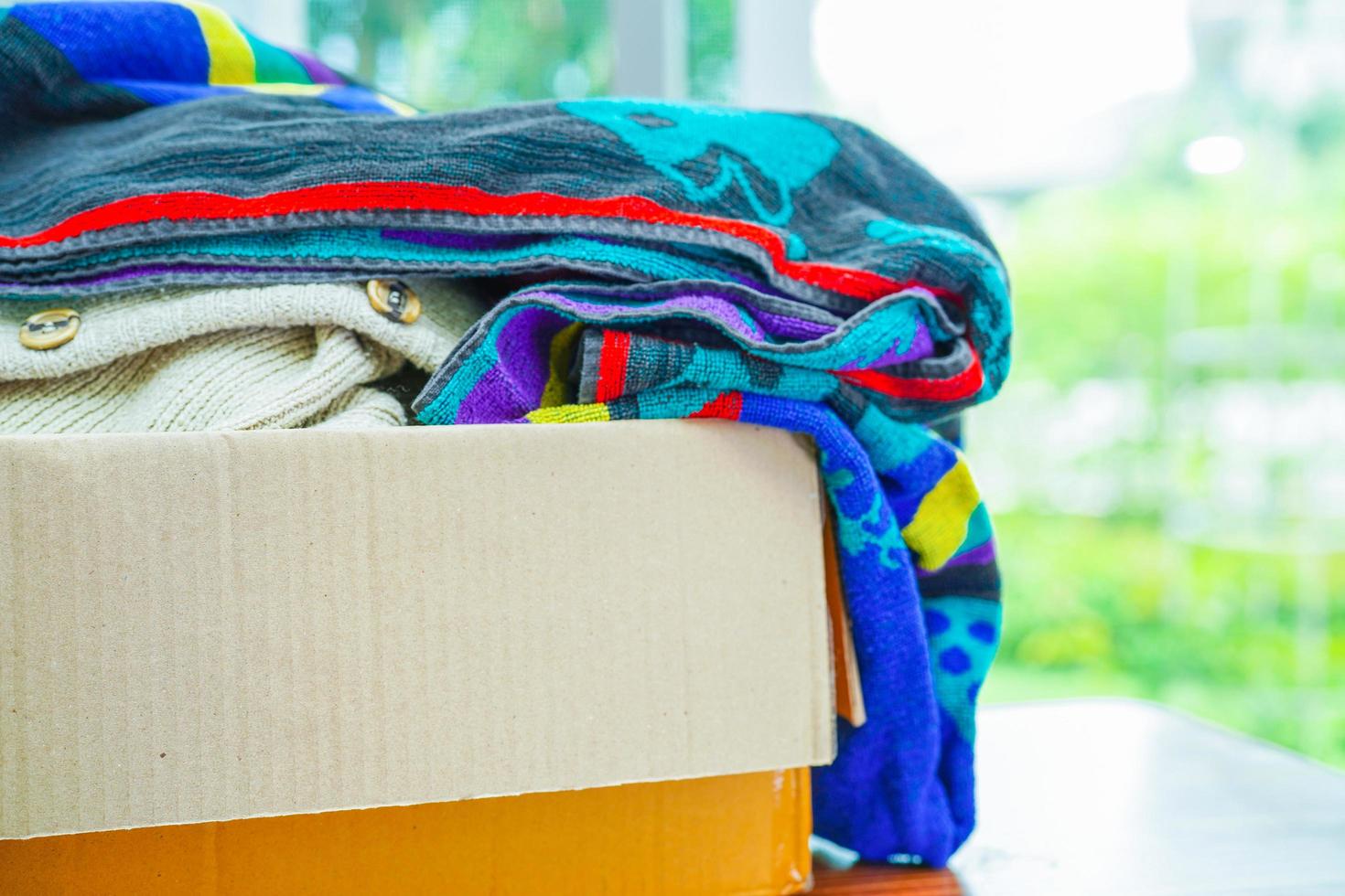 dons de vêtements dans une boîte en carton pour les bénévoles. photo