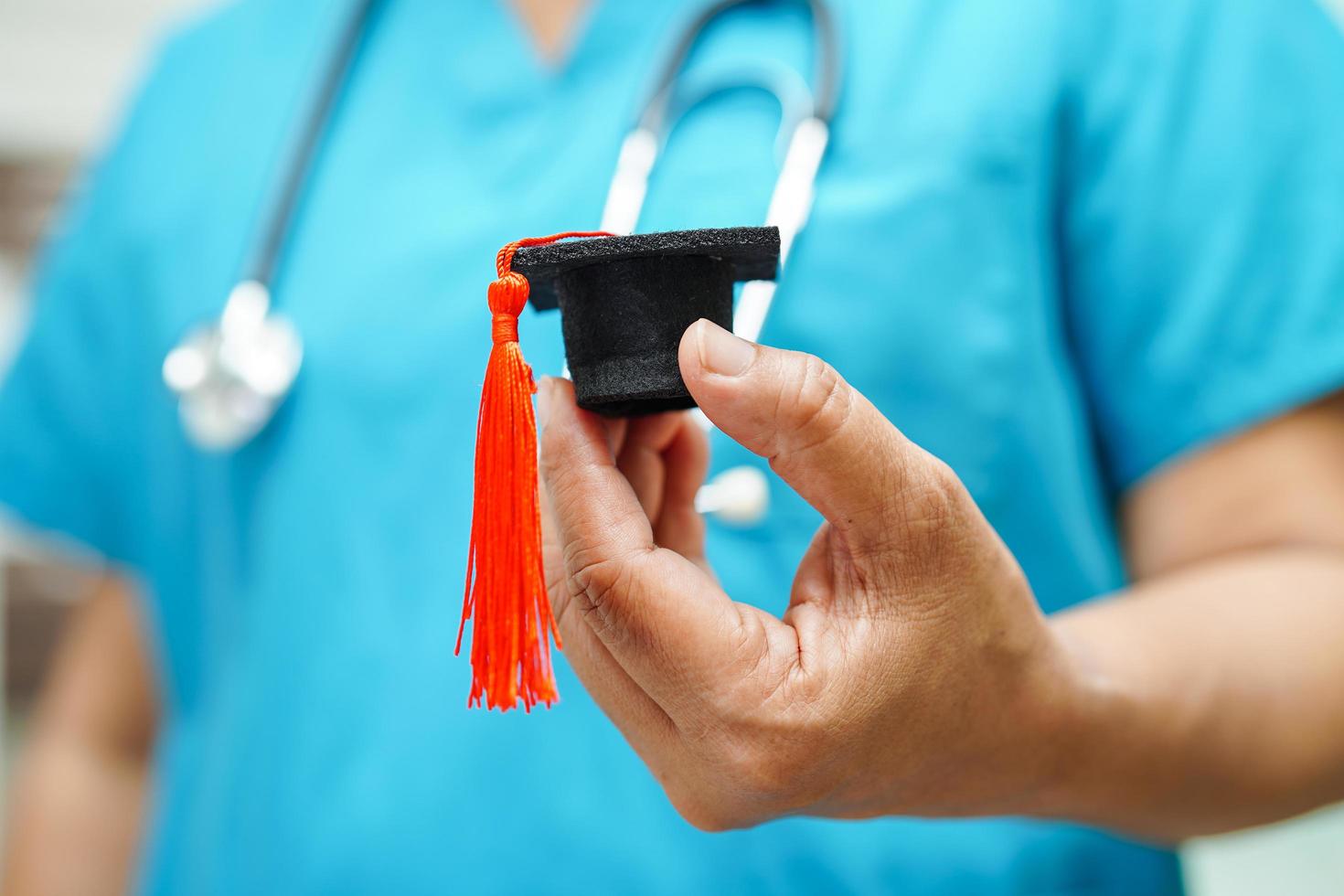 femme médecin asiatique tenant un chapeau de graduation à l'hôpital, concept d'éducation médicale. photo