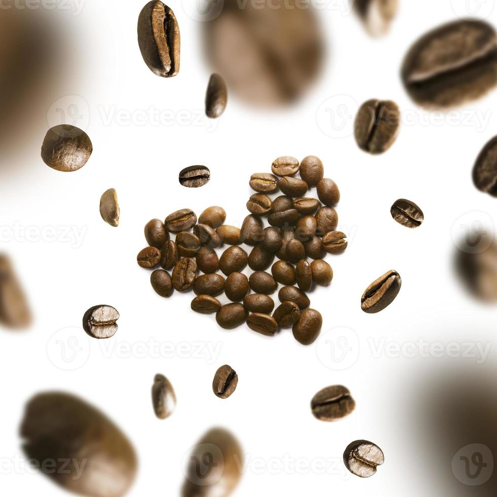 grains de café en forme de coeur en vol sur fond blanc photo