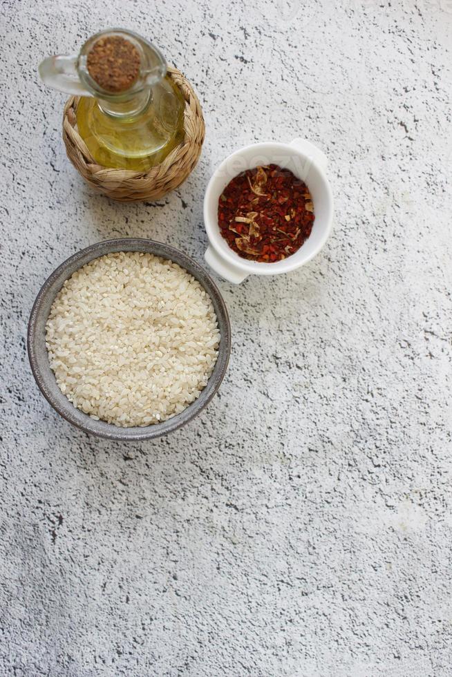 ingrédients pour la paella. bol gris avec du riz sur fond avec espace de copie pour votre texte, vue de dessus. alimentation naturelle riche en protéines photo