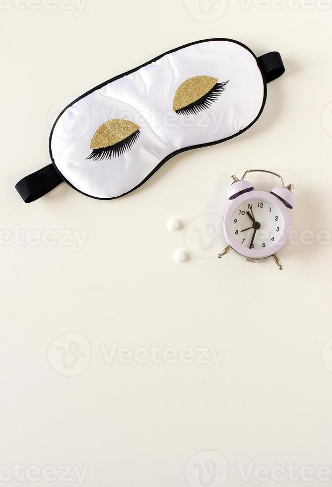 composition à plat avec masque pour les yeux de sommeil, livre de rêve et réveil sur fond. concept de sommeil sain. photo