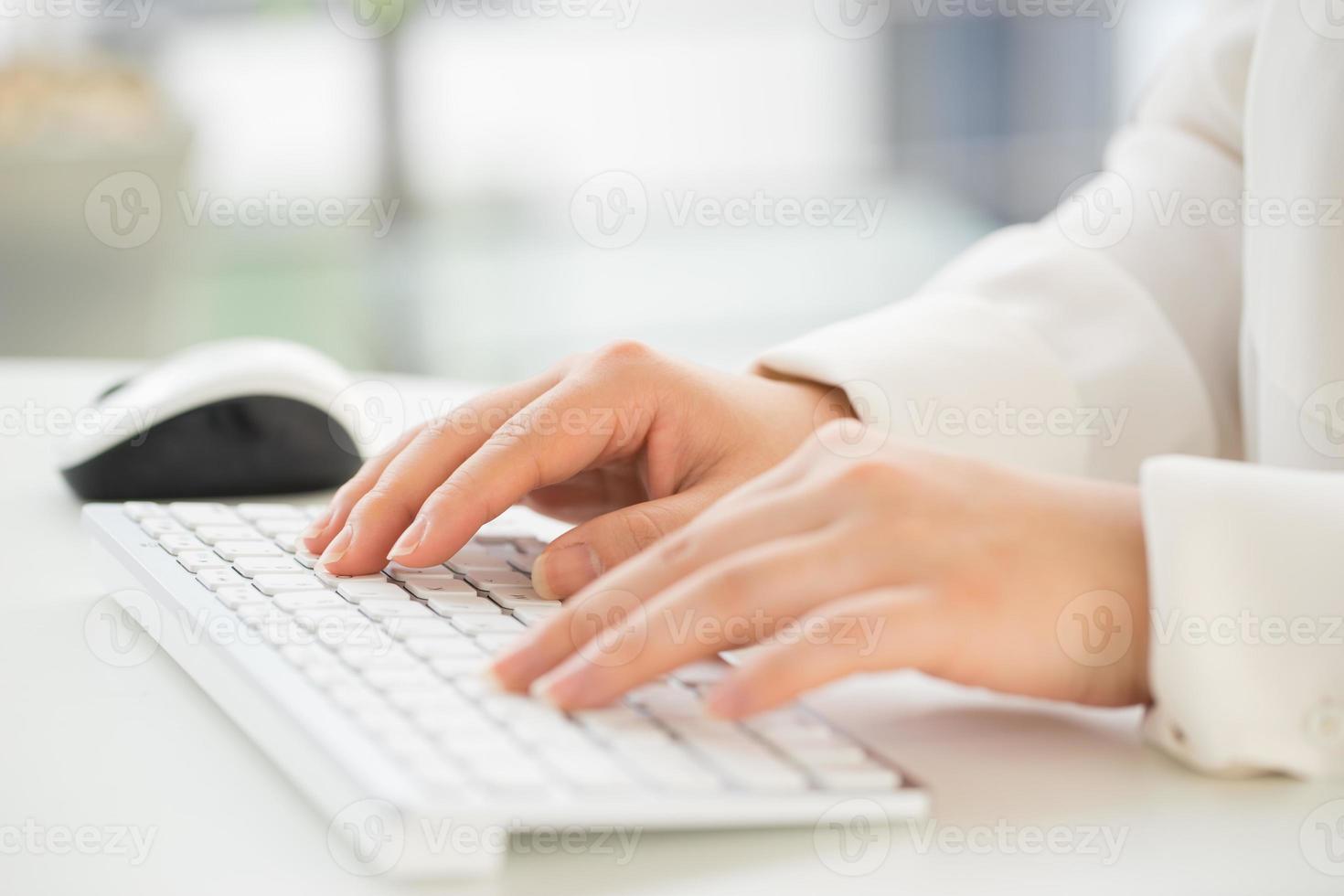mains d'une femme de bureau clavier de frappe avec carte de crédit photo