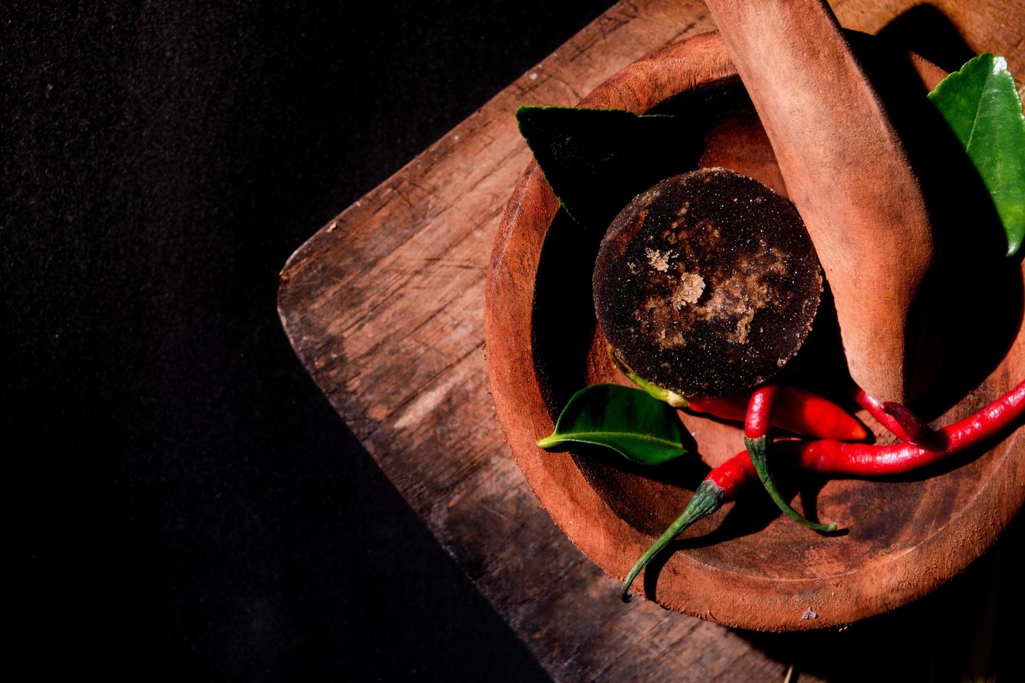 fines herbes sur mortier et pilon en bois. cassonade, piment photo. adapté à la bannière de restaurant et au papier peint photo