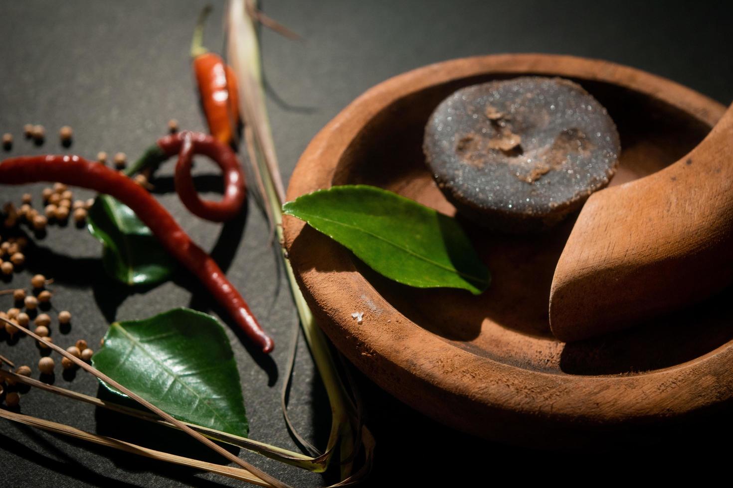 fines herbes sur mortier et pilon en bois. cassonade, piment photo. adapté à la bannière de restaurant et au papier peint photo