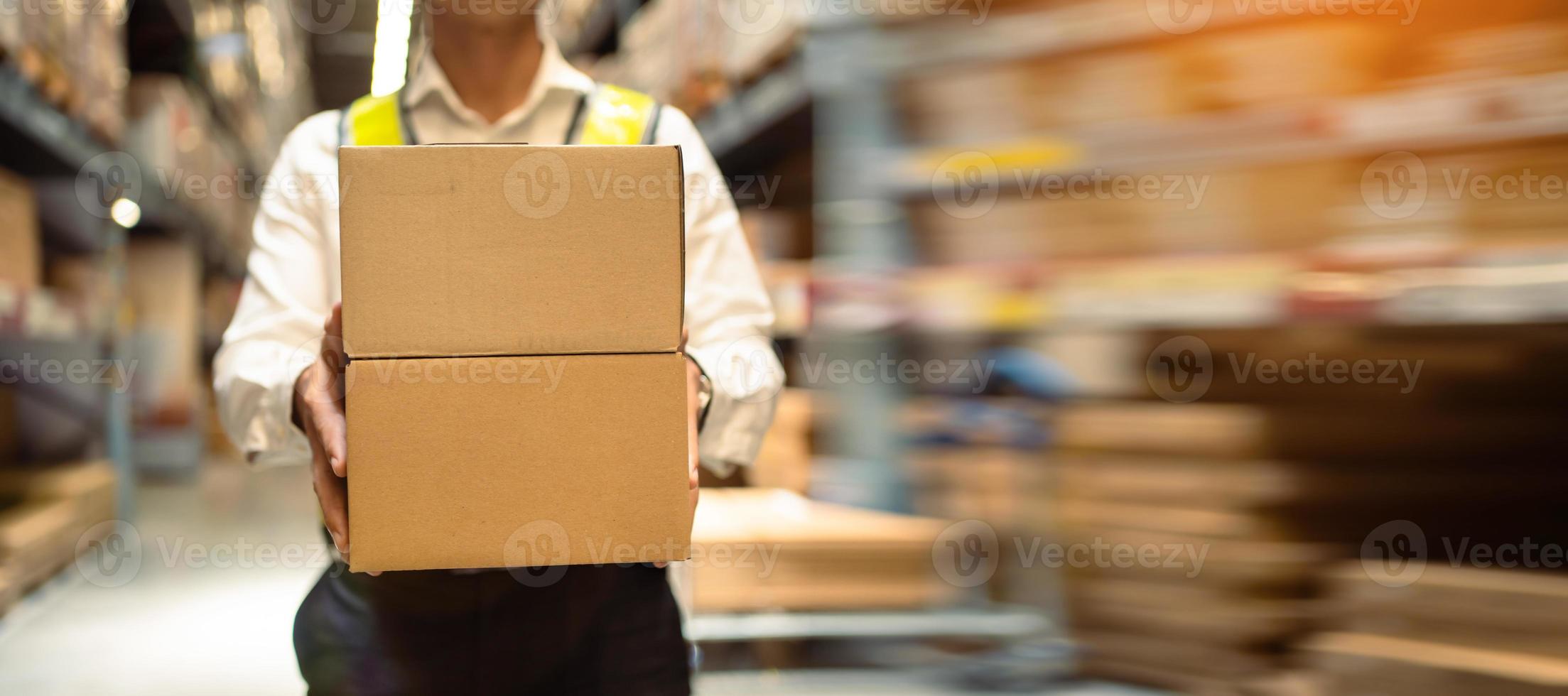 gros plan, ouvriers transportant des cartons dans un grand entrepôt logistique. concept de système logistique export-import. boîte à colis à l'entrepôt, emballage, livraison, entrepôt, image de bannière photo