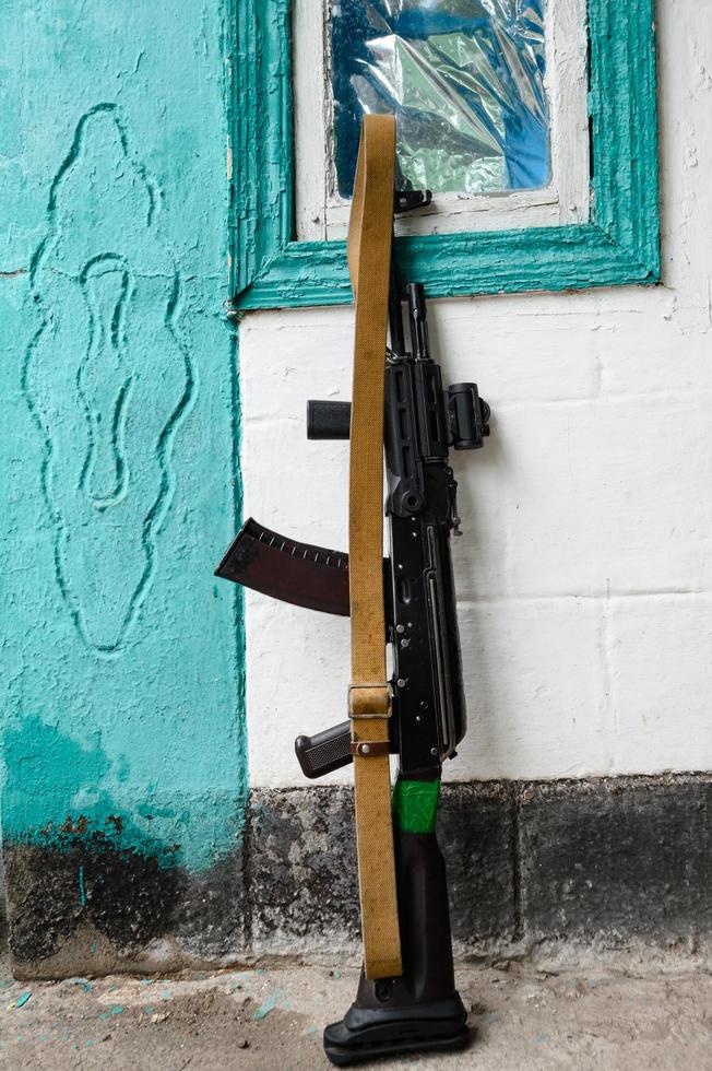 les fusils d'assaut militaires de combat du soldat ukrainien ak 74 sont appuyés contre le mur de la maison, la guerre en ukraine. photo